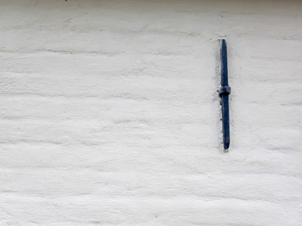 Detail van een muuranker op een buitengevel van een woning, geschilderd met Artisan Stucco Kalei buitenverf in Ebro White helder wit