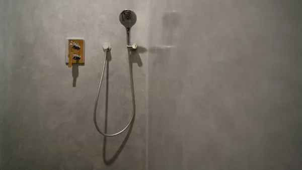 The fine, mirror-like gloss of Artisan Stucco's Pearl Grey Waterproof Stucco brings a rich depth to this minimalist shower in Sint-Oedenrode. Water droplets bead perfectly on the silky, breathable lime surface.